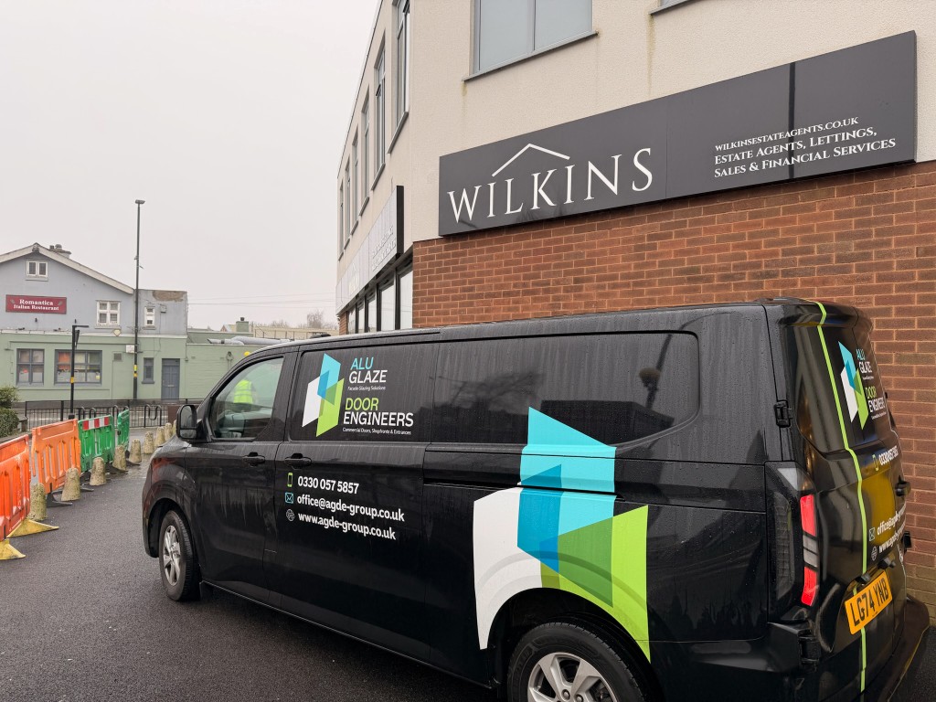 Door Engineers and Alu-Glaze branded service van parked outside a commercial premises