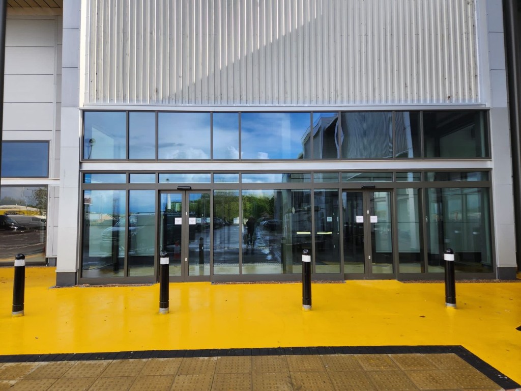 ASSA ABLOY automatic bi-parting door operators integrated with aluminium shopfront at Home Bargains in Wiltshire