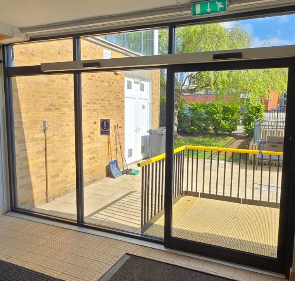 Automatic sliding door with header operator & safety sensors during operational adjustment