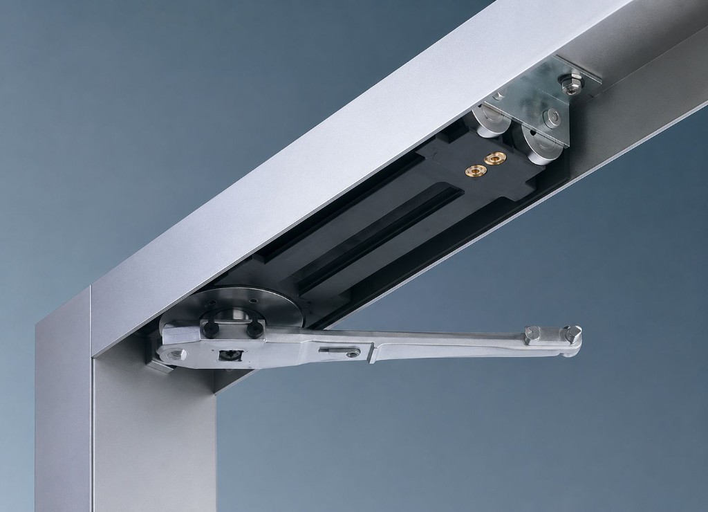 Concealed transom closer with drive arm & pivot assembly installed within an aluminium door frame
