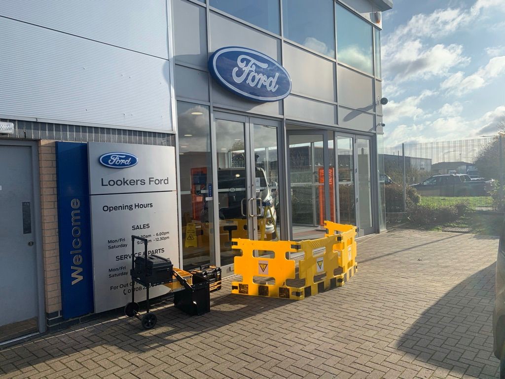 Commercial Glass Entrance At Lookers Ford With Safety Barrier And Maintenance Equipment During Door Closer Repair Works