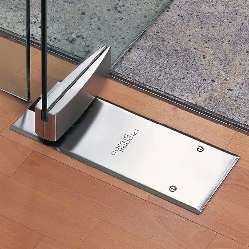 Dormakaba floor spring & patch fitting on a frameless glass door set into a wooden floor