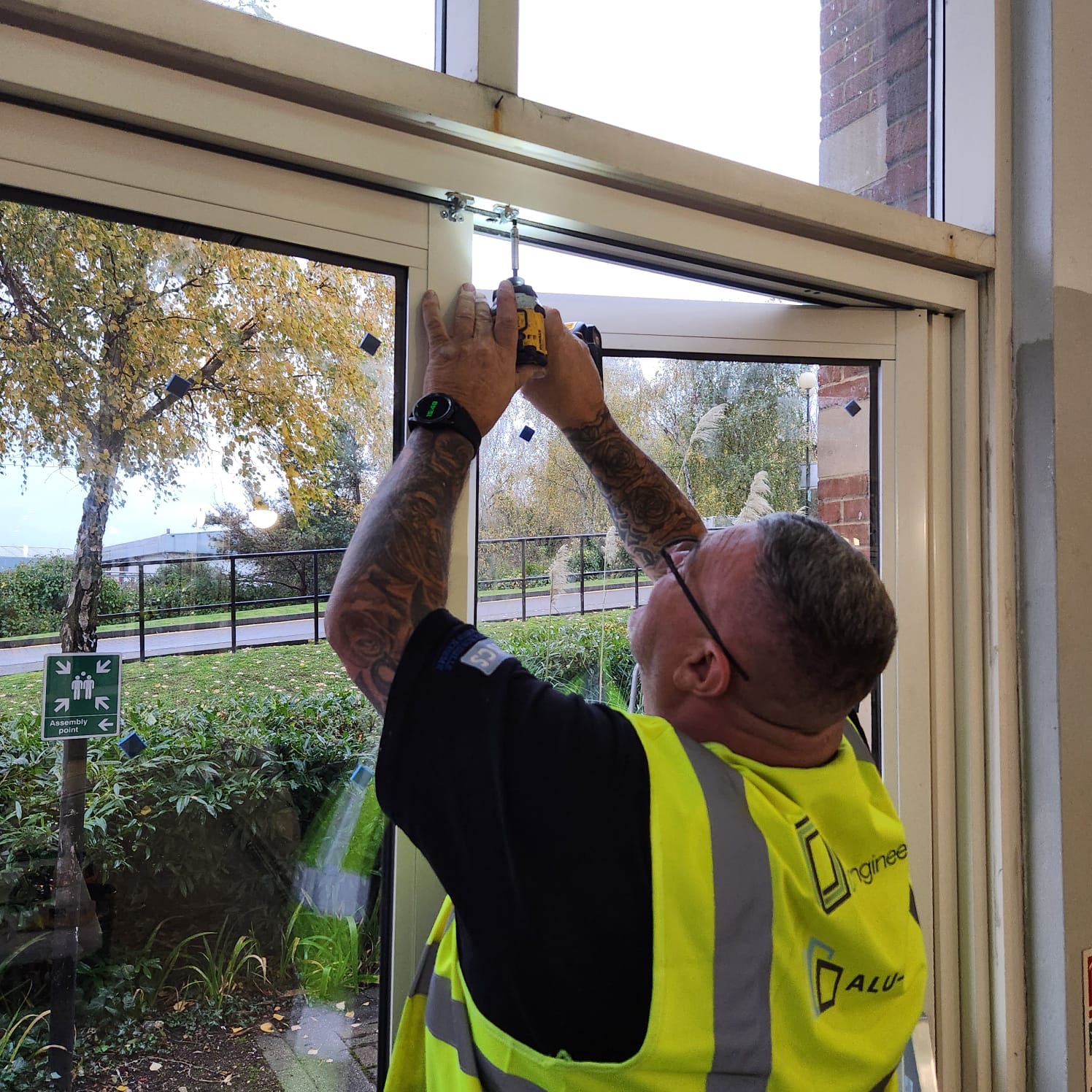 Door Engineers technician adjusting commercial door hardware during a repair visit