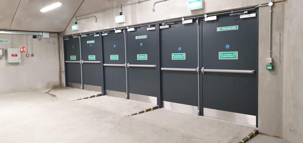 Steel Fire Exit Double Doors With Panic Bars And Exit Signage In A Commercial Plant Room