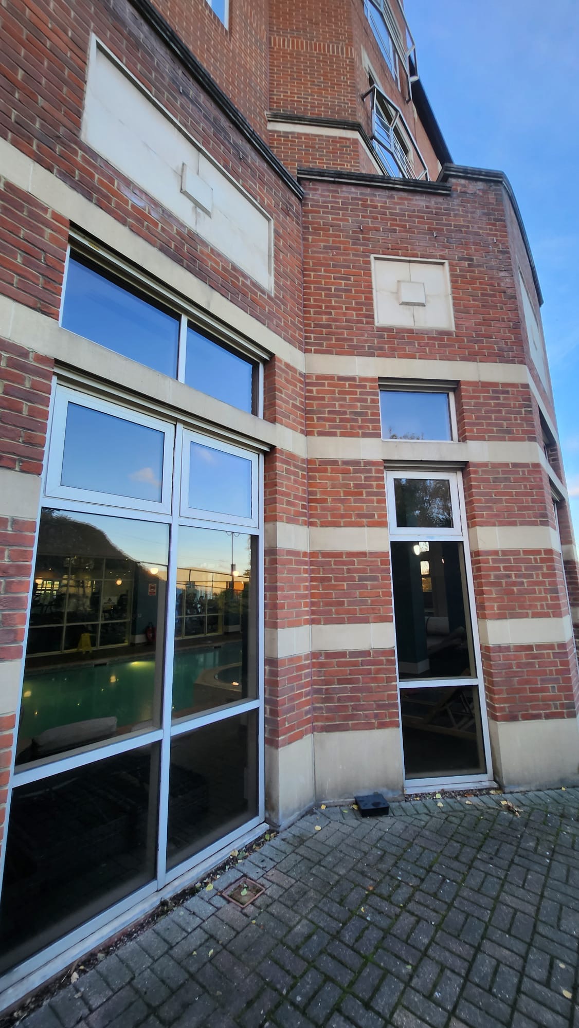 Glass-partitioned commercial interior for frameless glass door maintenance context
